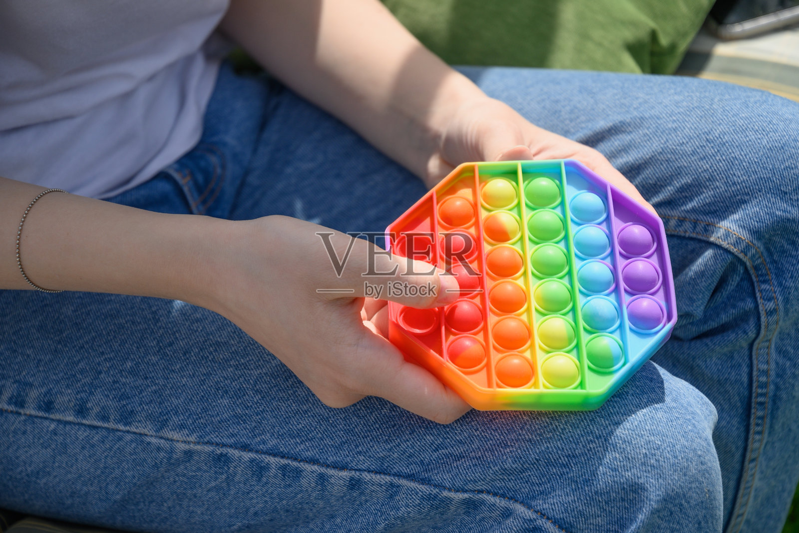 女孩玩硅胶抗应力Pop它在六角形玩具。照片摄影图片