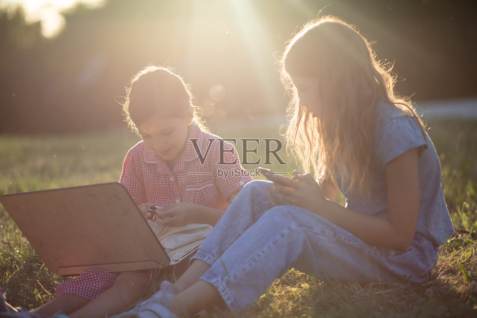 两个小女孩在户外使用科技产品照片摄影图片