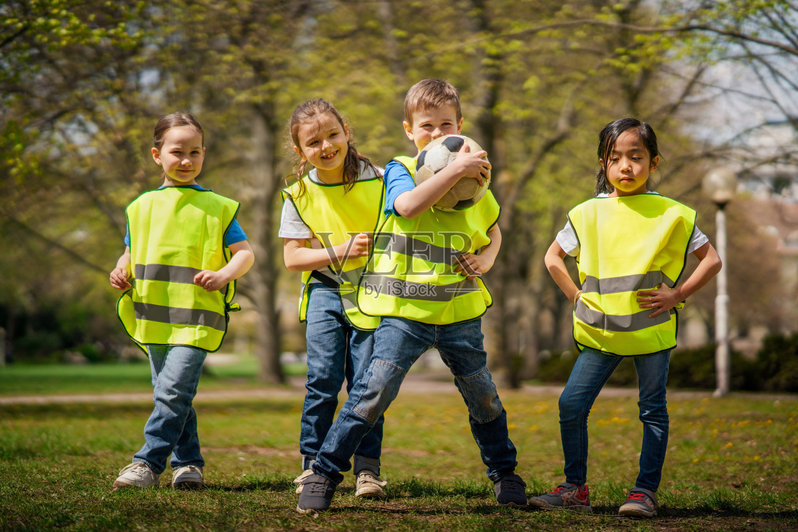 幼儿带着球在城市公园户外看相机,学习小组教育理念。照片摄影图片