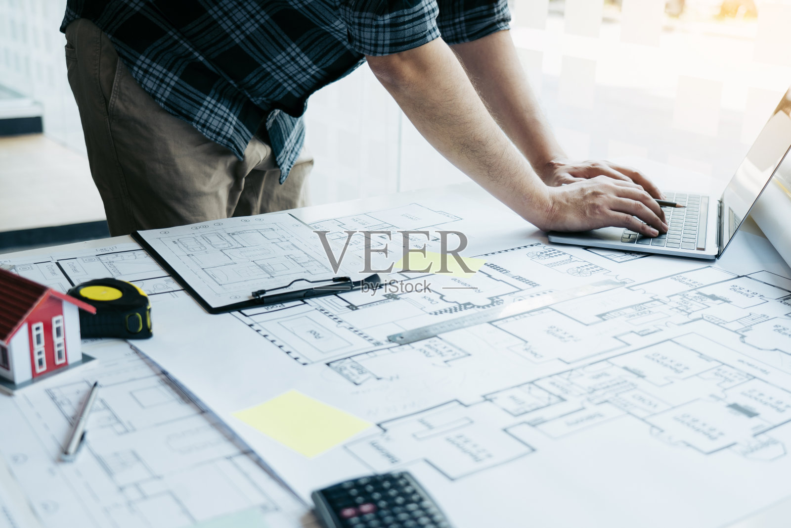 建筑师工作的新项目和使用笔记本电脑在办公室。照片摄影图片