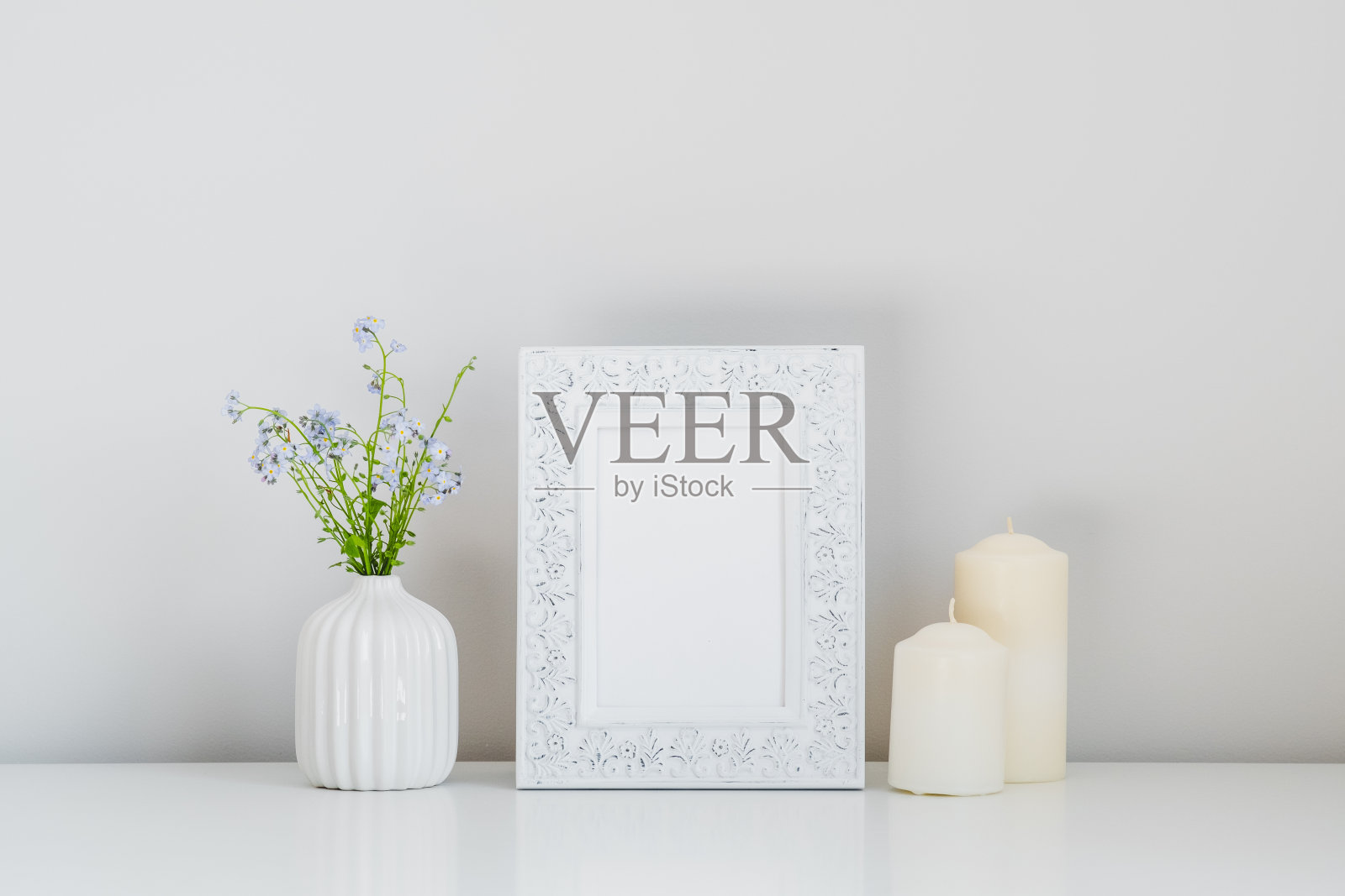 相框模型,蜡烛,花瓶与春天的花在白色的背景。照片摄影图片