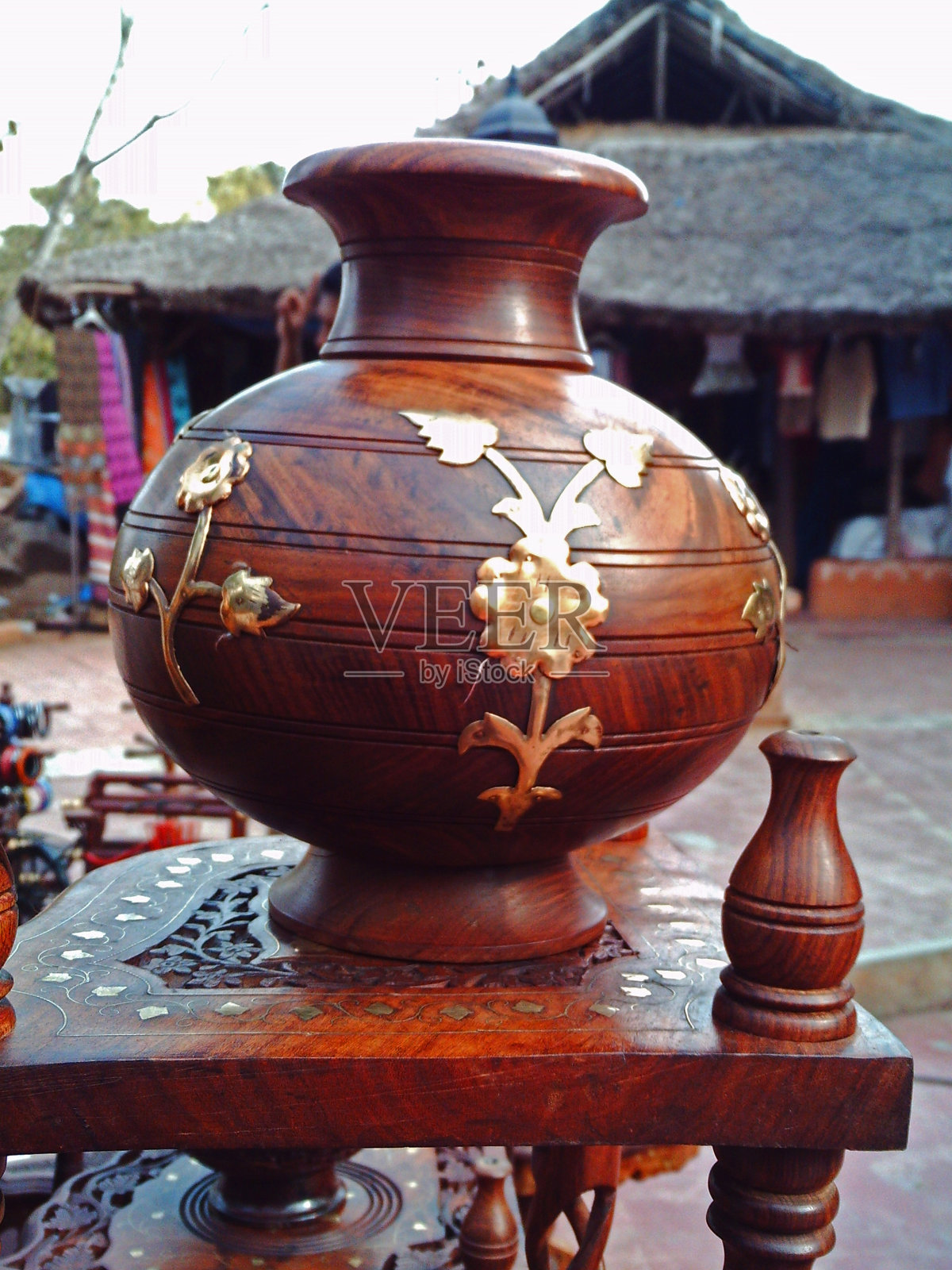 棕色手工木制花瓶与黄铜镀设计放置在木桌上照片摄影图片