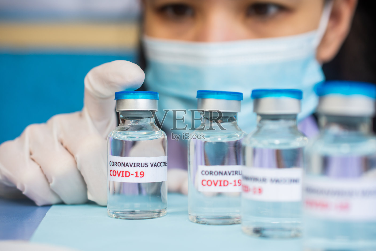 医生手持COVID-19疫苗用于给人注射COVID-19。照片摄影图片