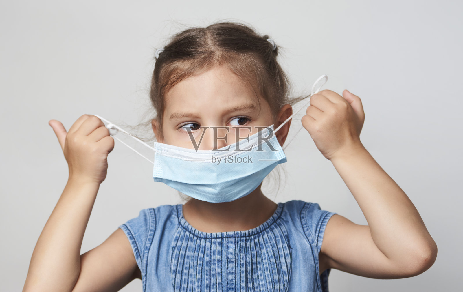 小女孩戴着面具,背景是白色照片摄影图片