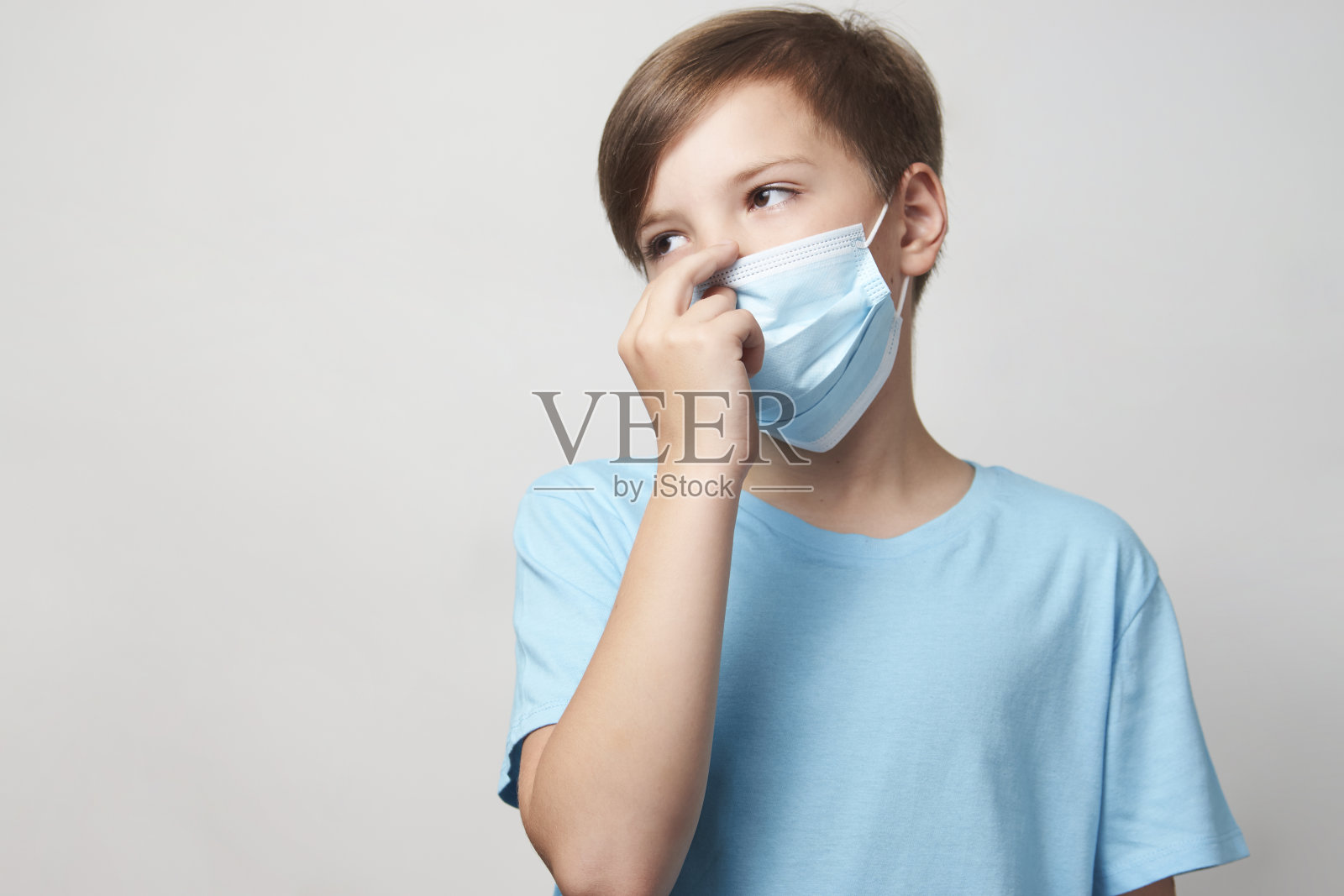 戴着白色背景面具的男学生照片摄影图片