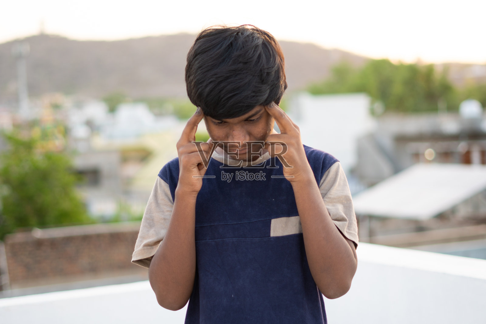 因头痛按摩头部的印度儿童特写照片摄影图片