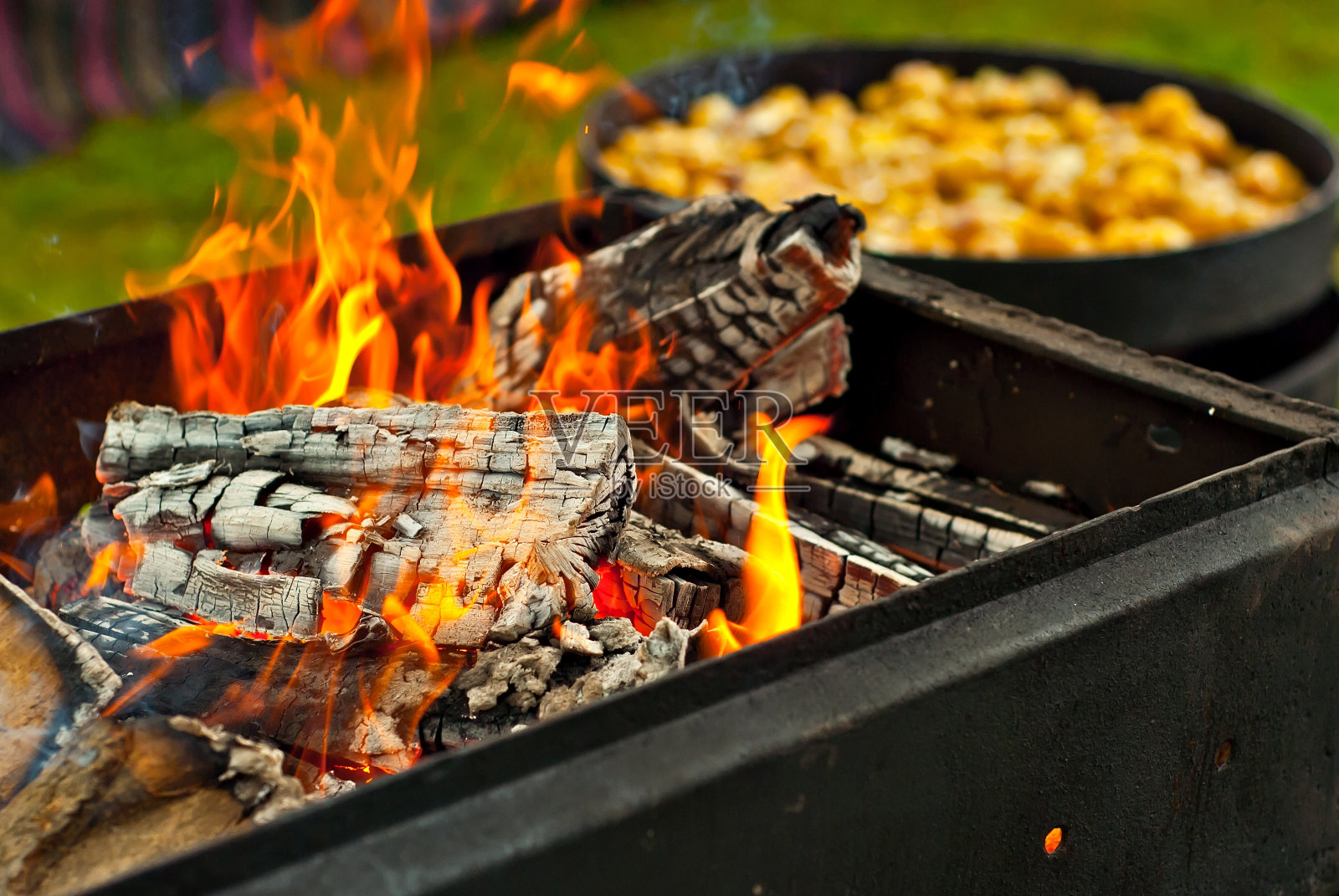 用大锅烤土豆。节日里的美味食物。灶台边的田野厨房。又圆又嫩的土豆在油里炸。清晰度着火了。照片摄影图片