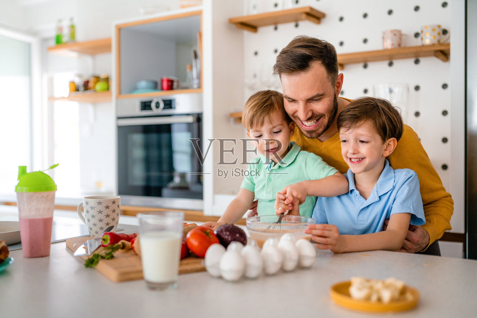 微笑的父亲和孩子们一起准备健康的食物和花时间在一起照片摄影图片