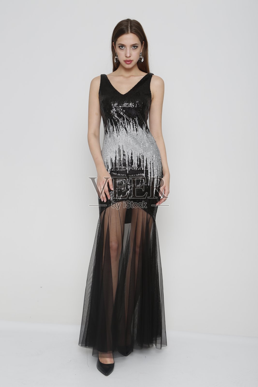 美丽的女人穿着长长的晚礼服,前面是白色的背景照片摄影图片