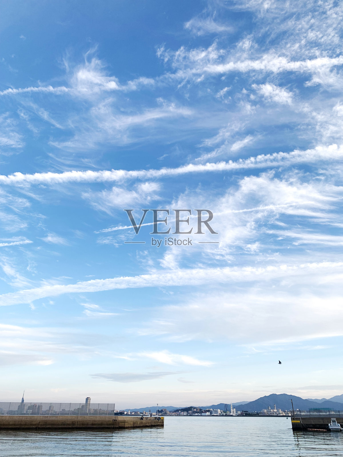 从日本野之岛俯瞰福冈市,阳光下有一些尾迹照片摄影图片