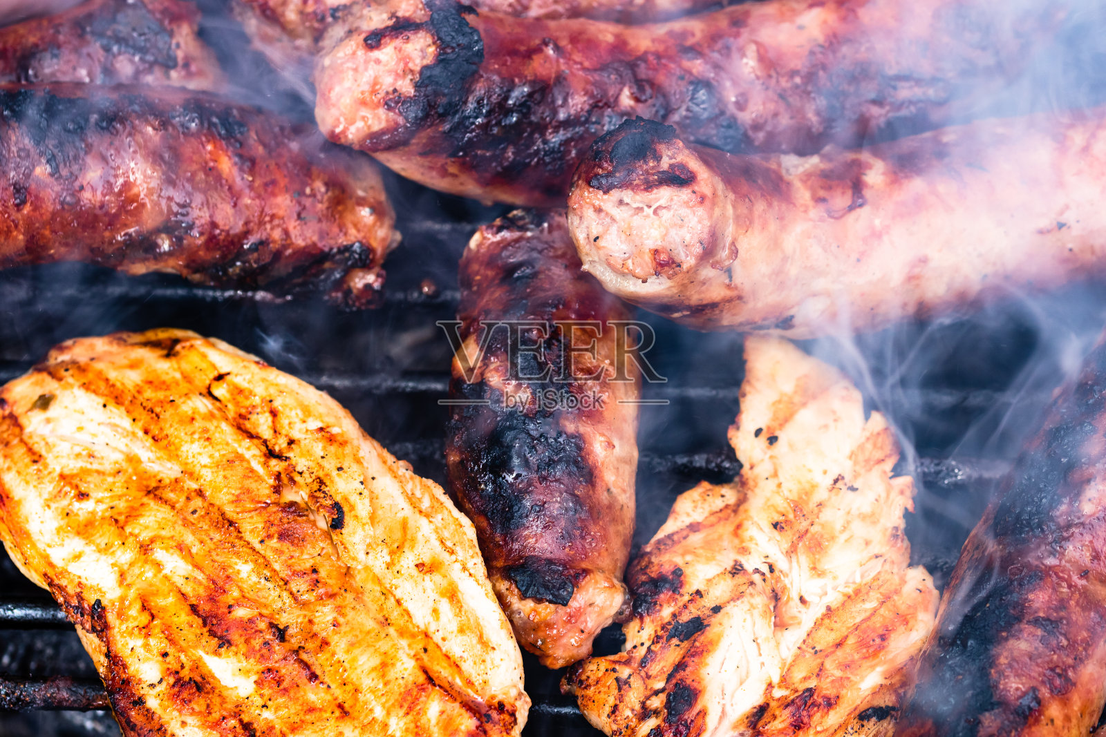 近距离观察自制鸡肉,猪肉排和香肠的烧烤细节。烧烤,烧烤和食物的概念。照片摄影图片