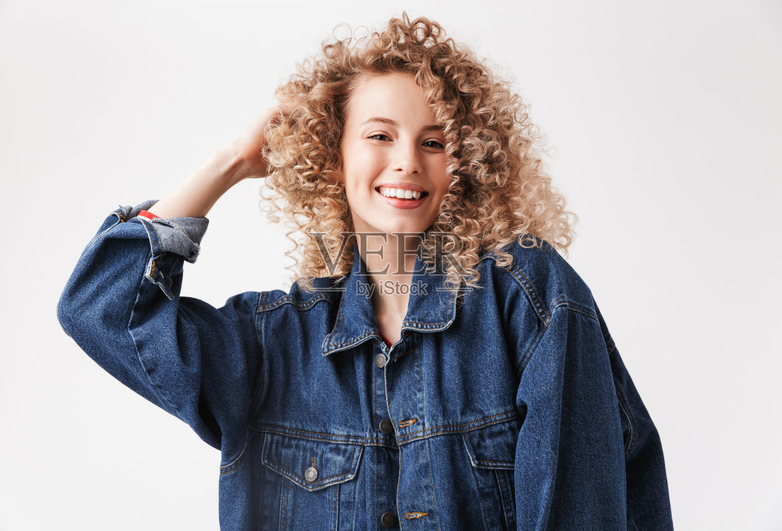 一个微笑的年轻女孩的肖像在牛仔夹克照片摄影图片