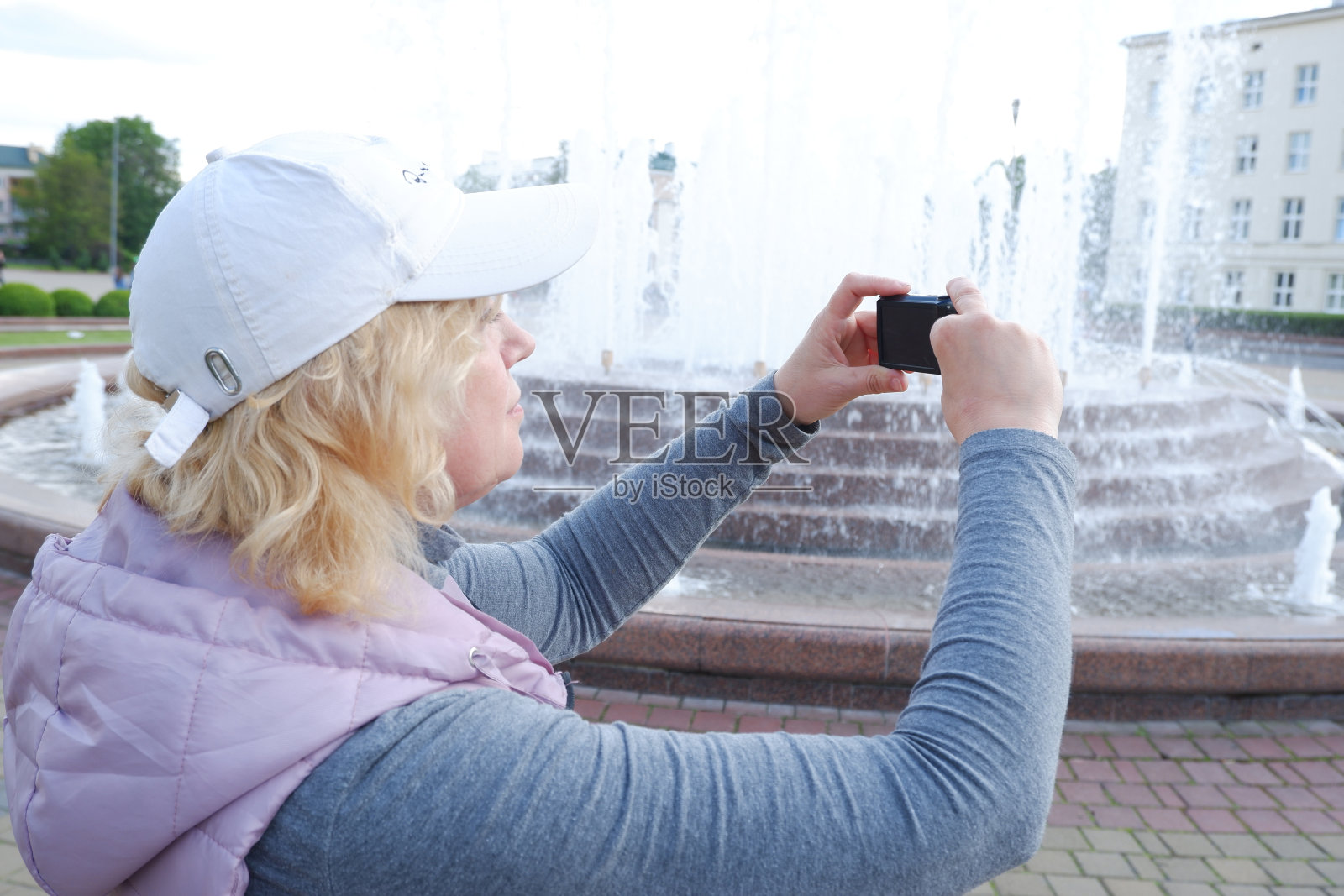 这个女孩在拍城市喷泉的照片。圣维罗妮卡节摄影师节。照片摄影图片