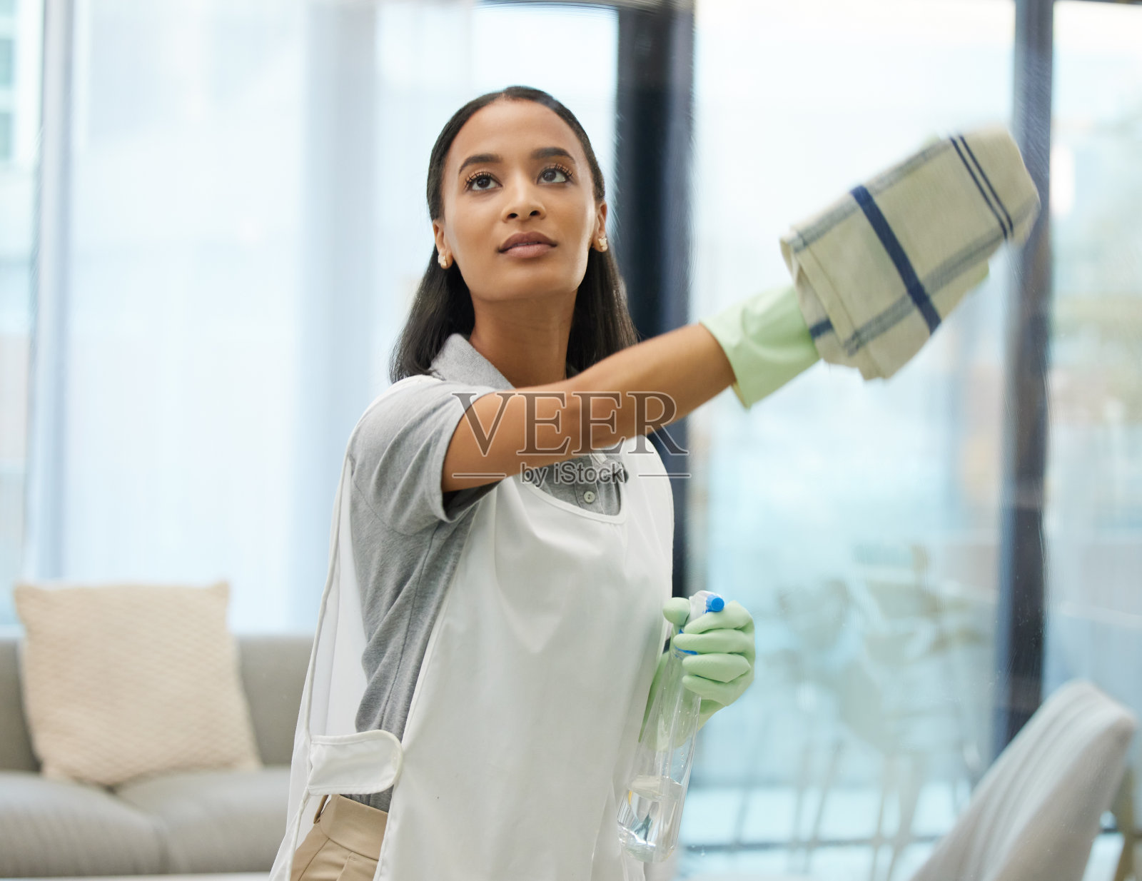一名年轻女子在家里清理玻璃表面的照片照片摄影图片