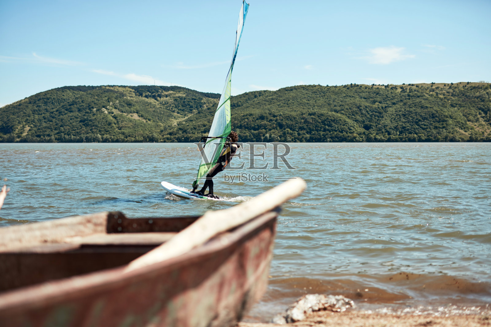 在一个刮风的夏日,在河边冲浪。照片摄影图片