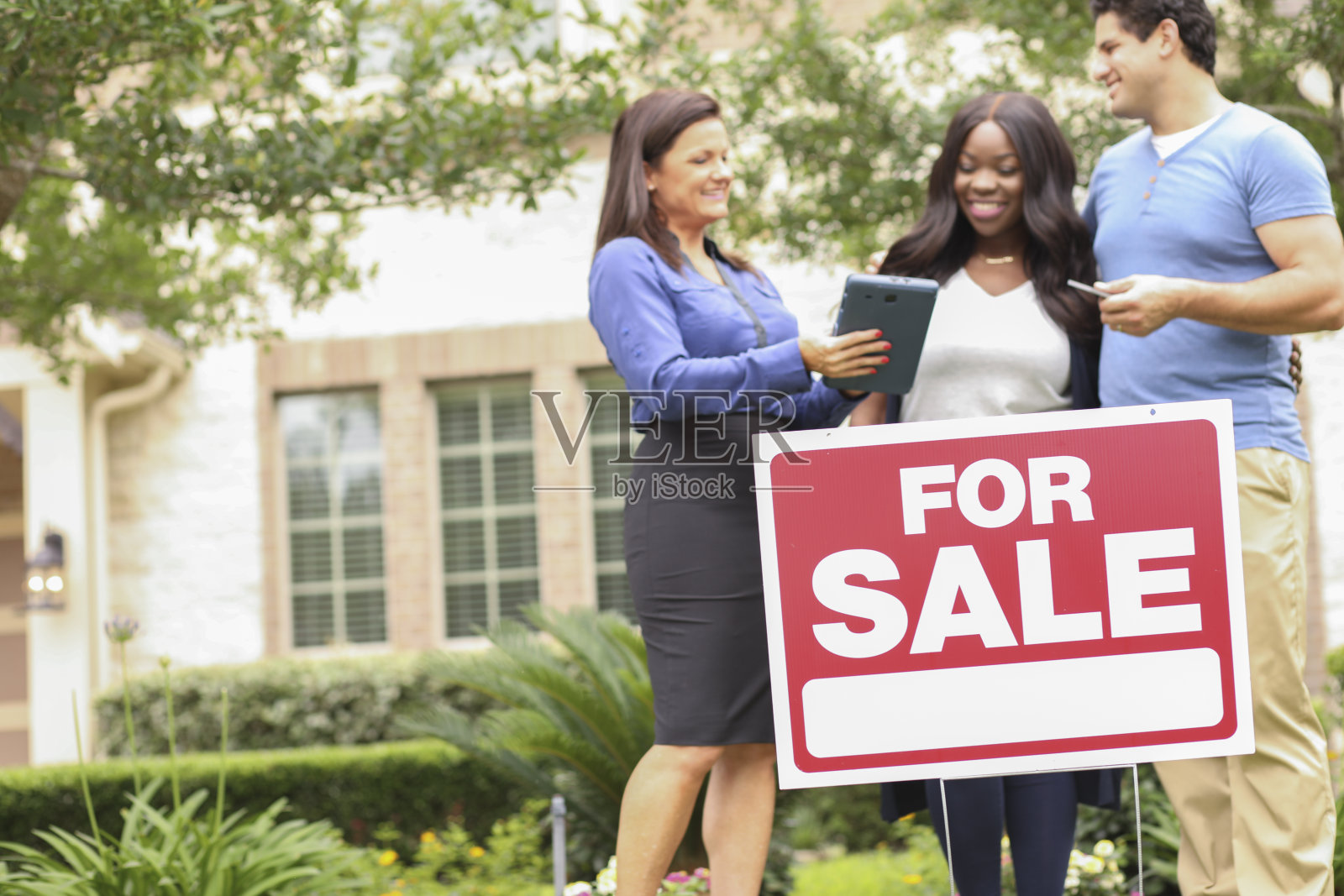 房地产经纪人和年轻夫妇买房。照片摄影图片