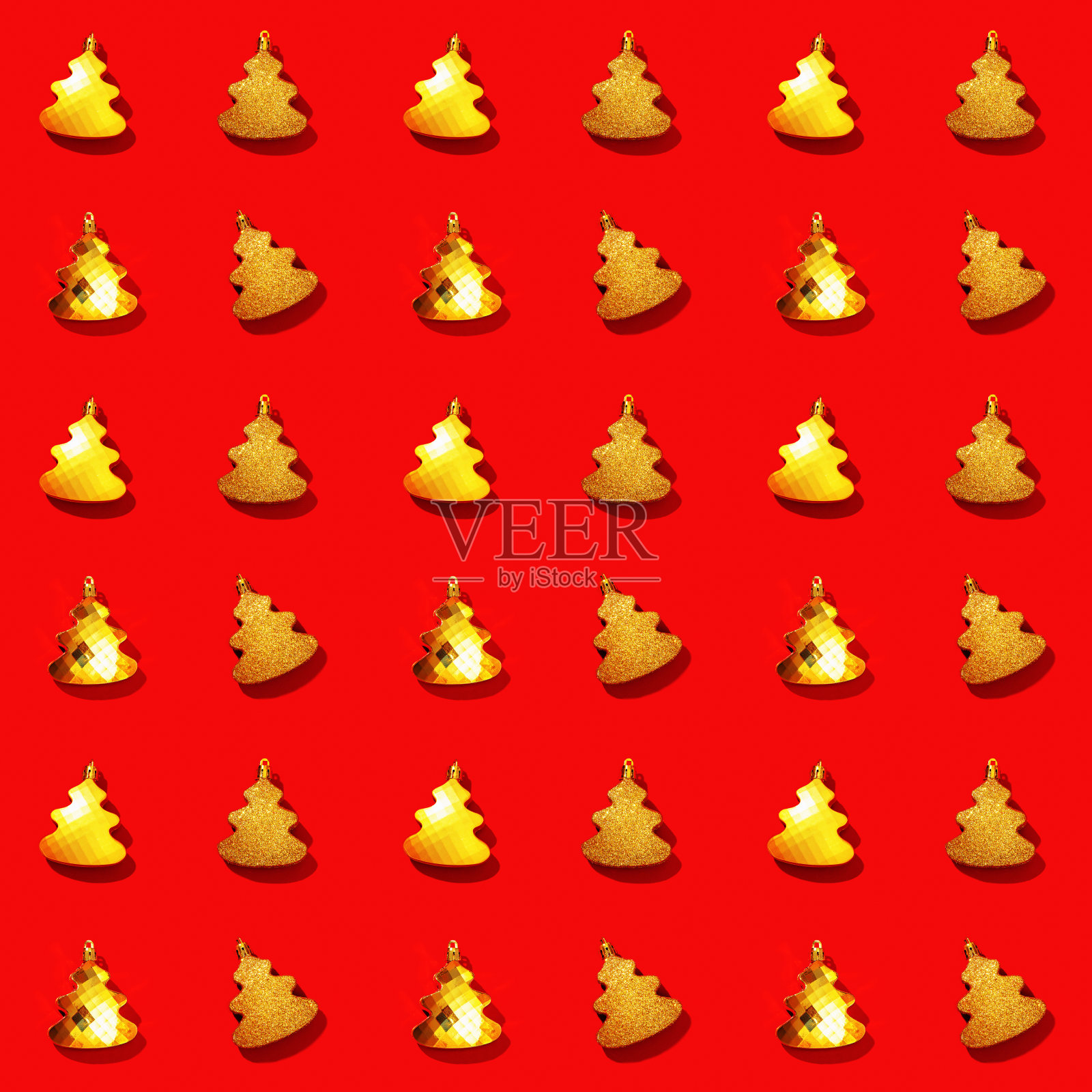 无缝规则的创意图案与金属金色圣诞树玩具上的红色。照片摄影图片