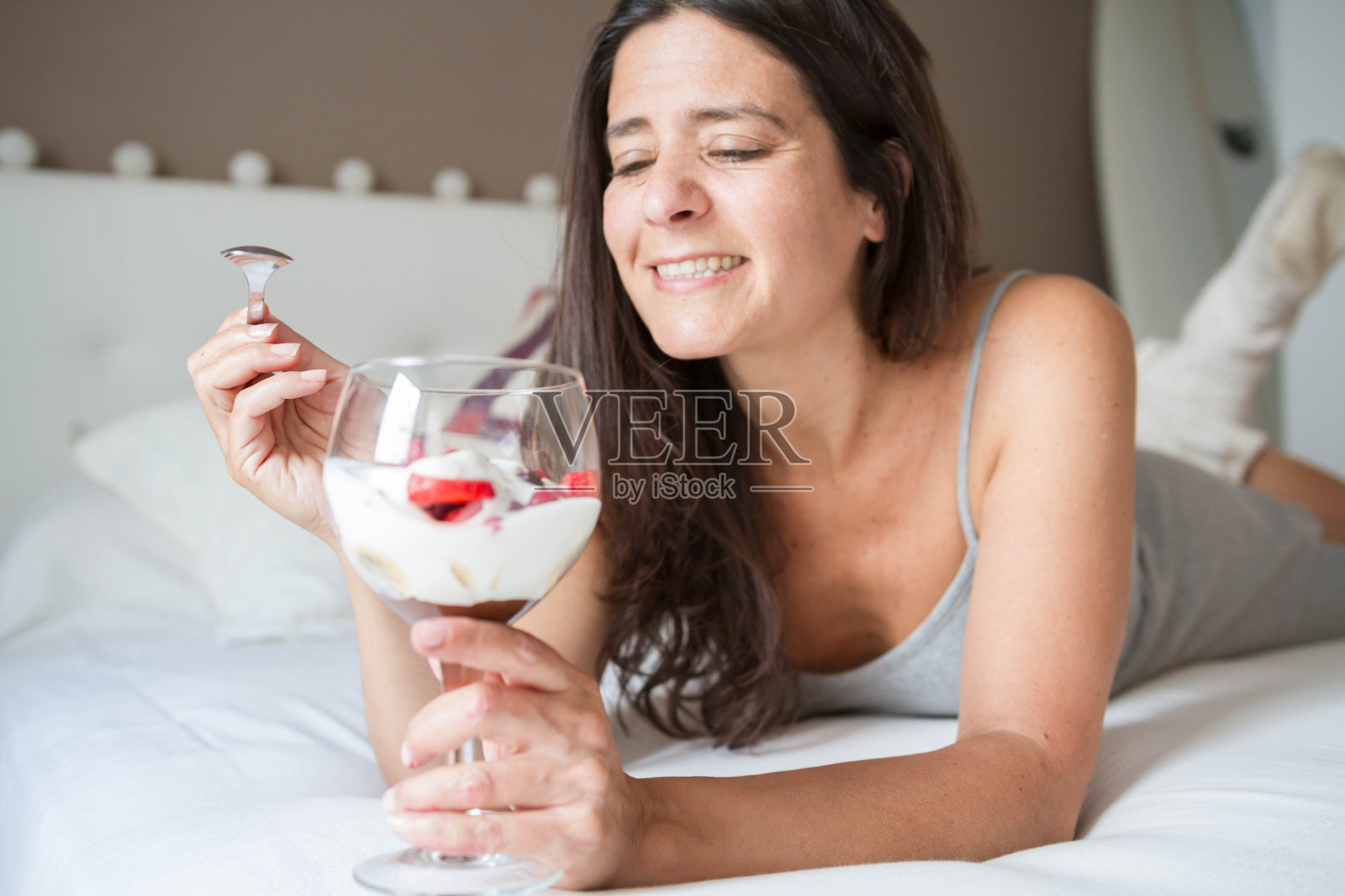 迷人的中年深色头发的西班牙女人与一杯冰激淋水果摆姿势照片摄影图片