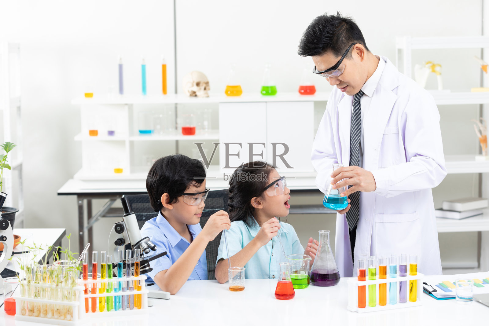 在实验室教室里,学生和科学老师一起做化学实验照片摄影图片