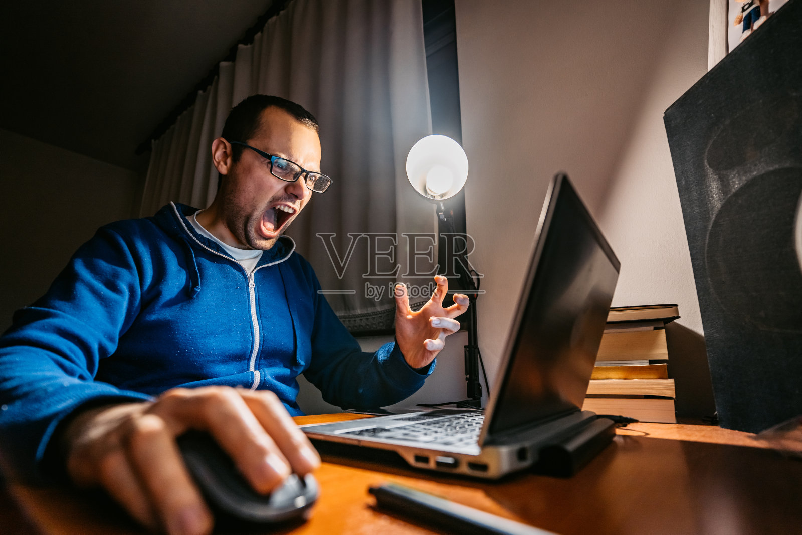 对着笔记本电脑大喊大叫的沮丧男子照片摄影图片