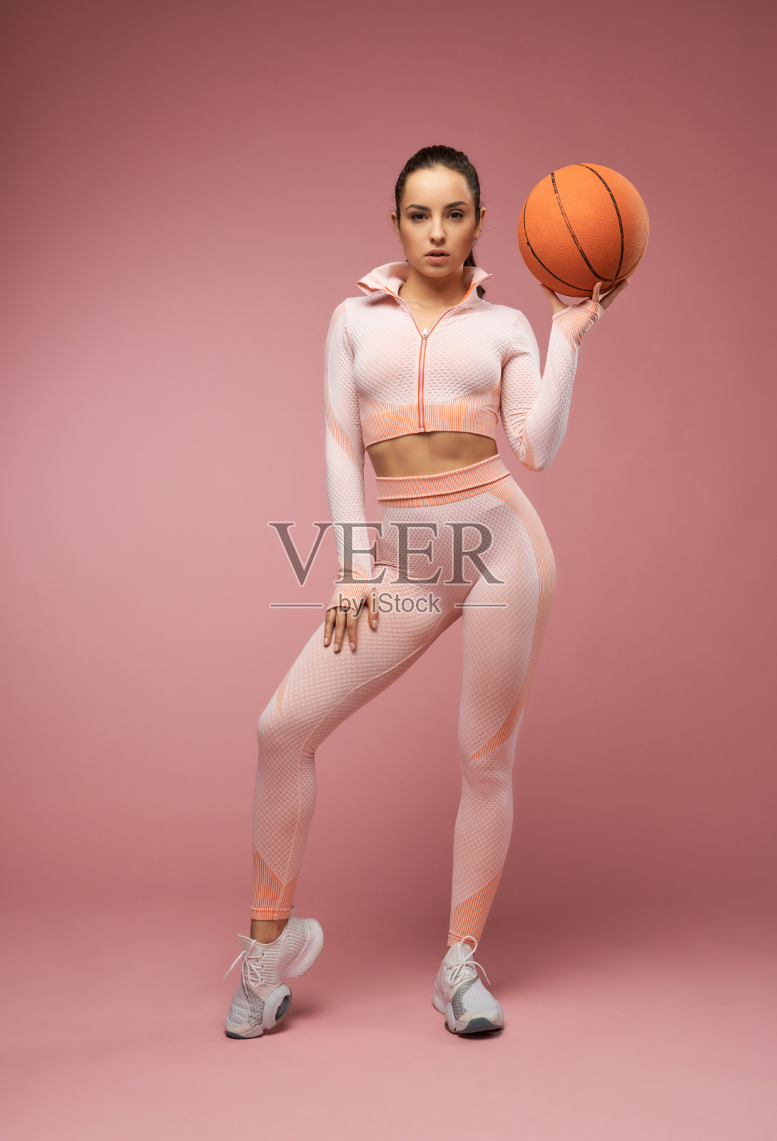 迷人的年轻女子拿着篮球站在演播室里照片摄影图片