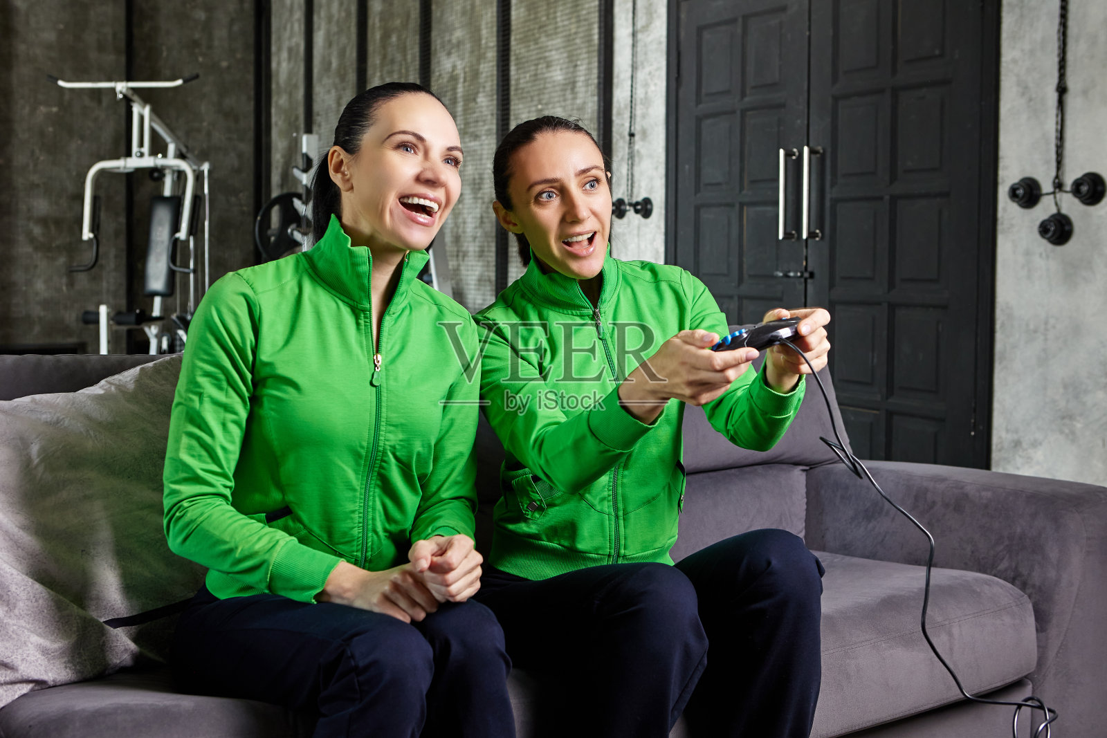 成熟的女性姐妹用游戏机玩电子游戏。照片摄影图片