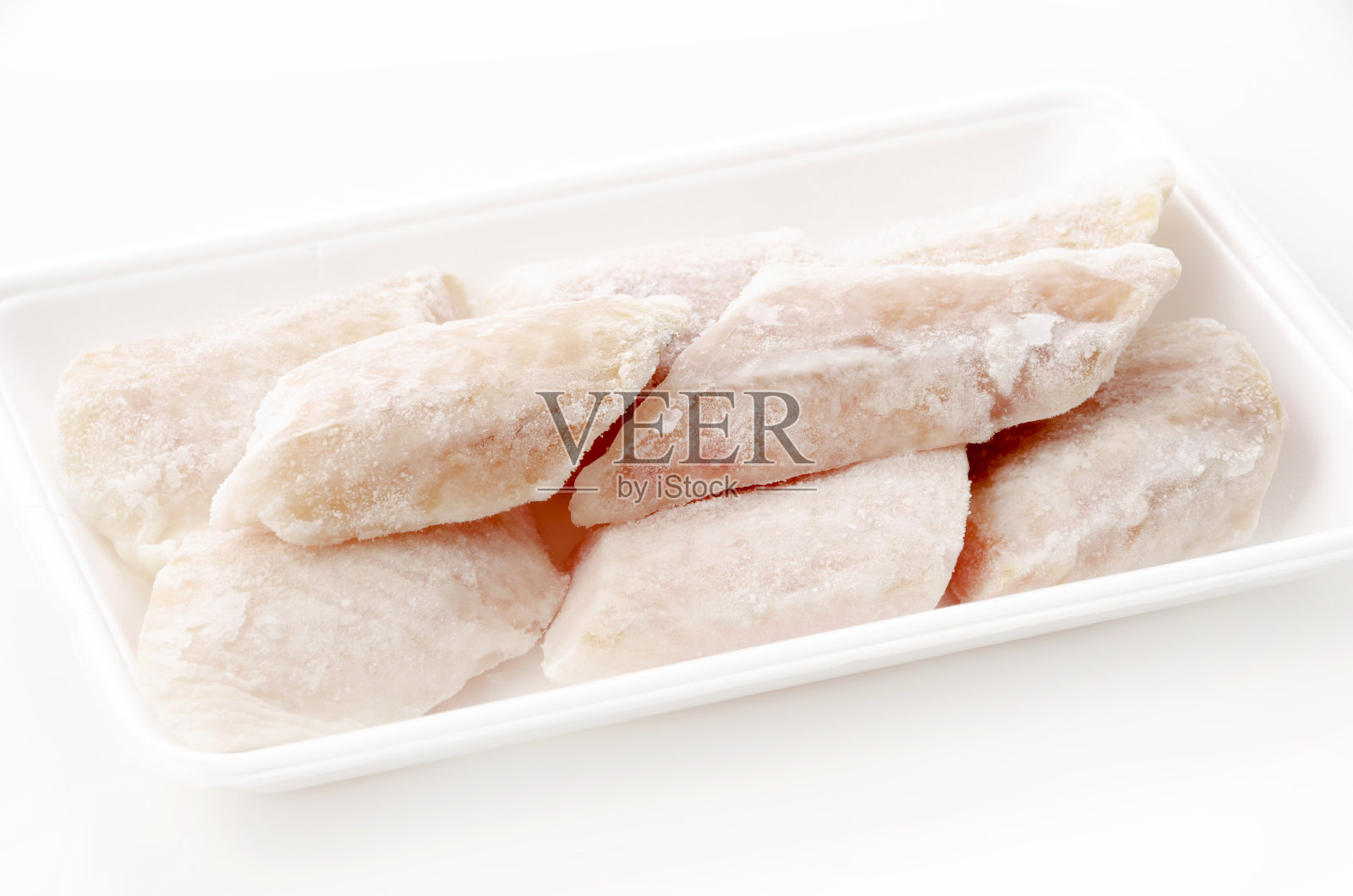 堪察加半岛的冻生鱼片比目鱼,泡沫托盘,白色背景照片摄影图片