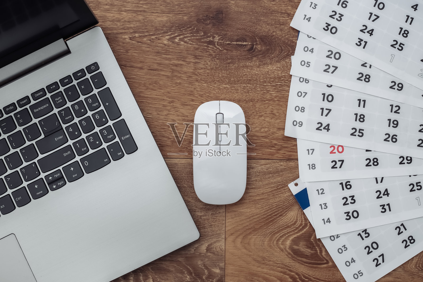 木制背景上有月历的笔记本电脑。俯视图照片摄影图片