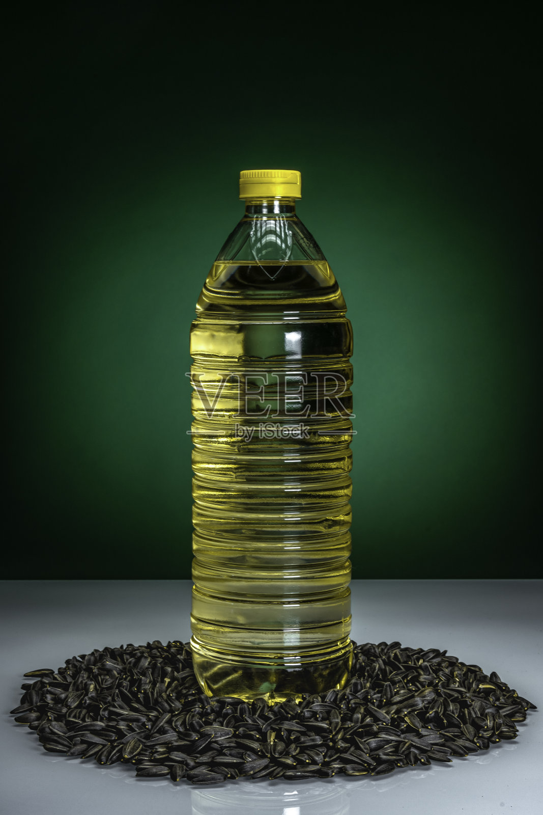 烹饪葵花籽油塑料瓶周围的葵花籽。照片摄影图片