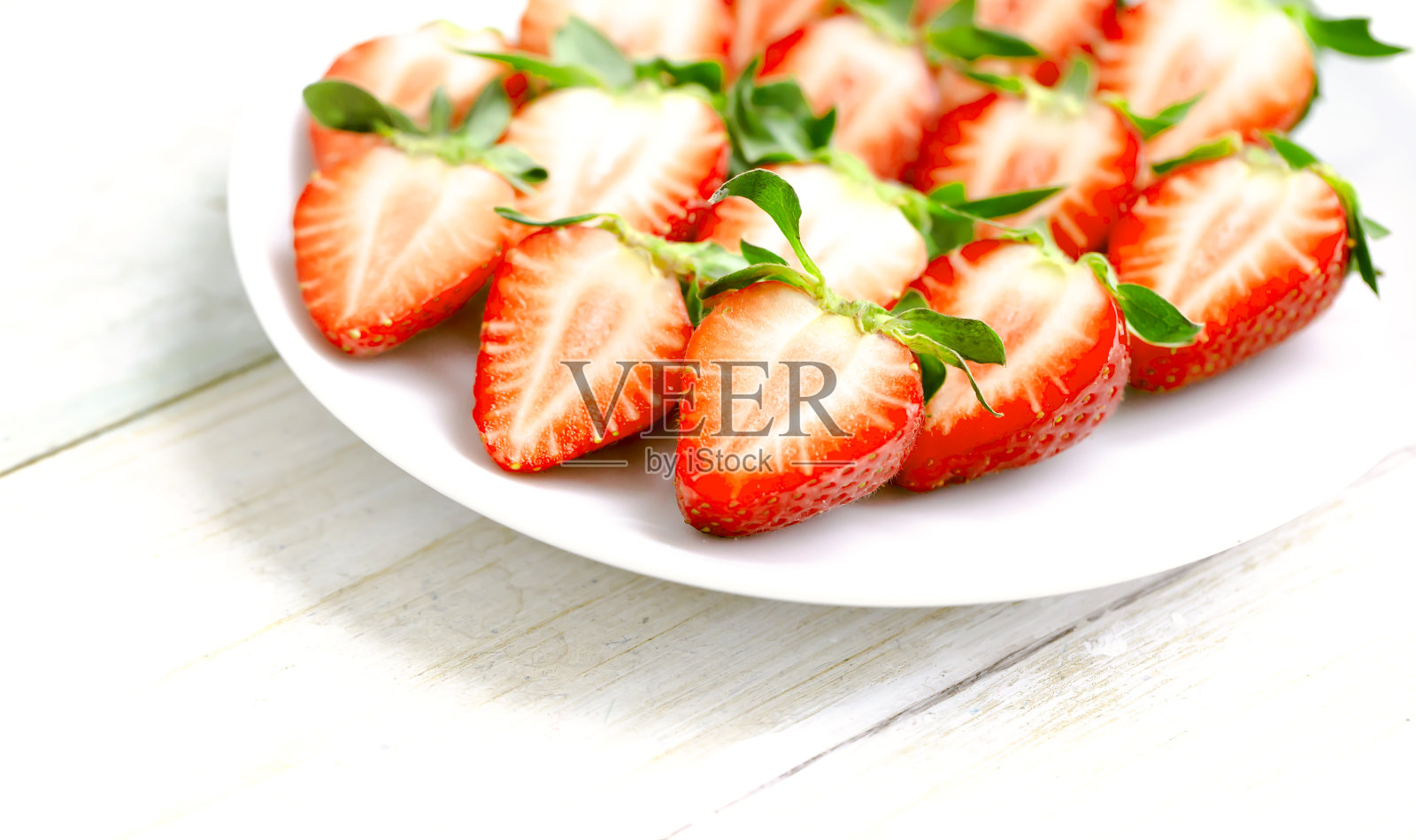 白色盘子里的成熟草莓。照片摄影图片