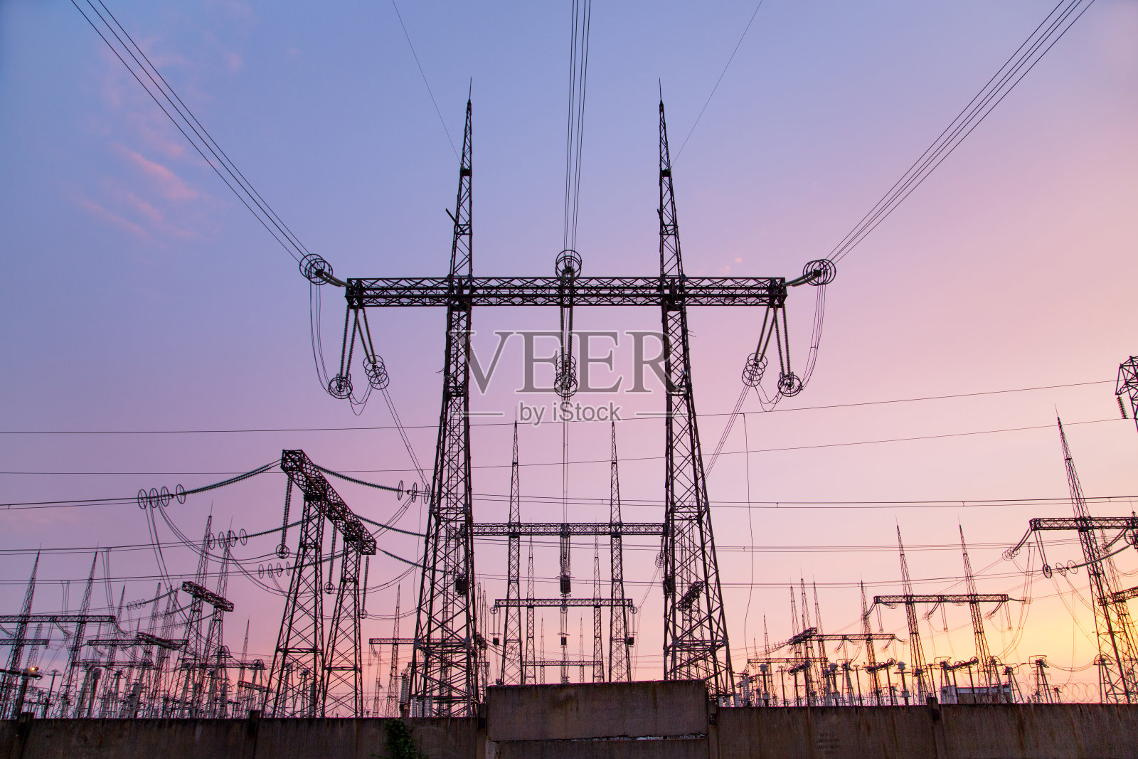 一个粉色日落背景下的超高压变电站。照片摄影图片