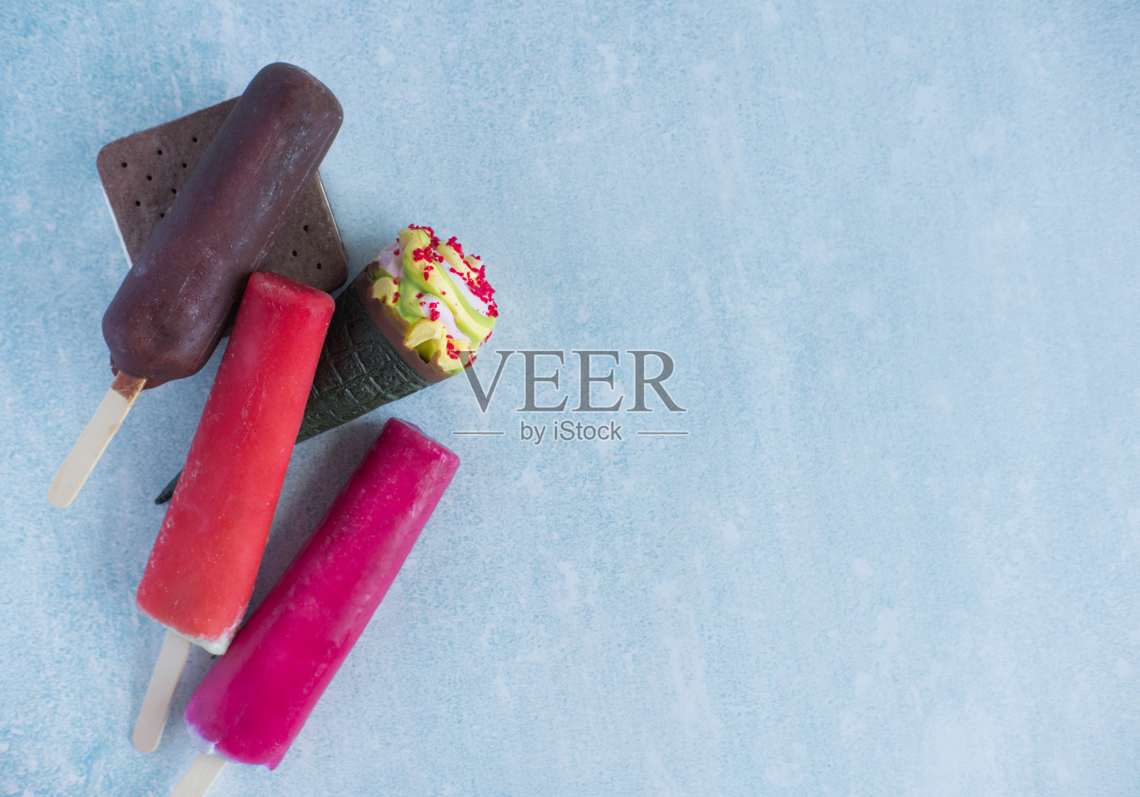 很多不同的冰淇淋在一个蓝色的背景和一个地方的题字。从顶部俯瞰夏日甜点的霜冻景色。网站上的横幅的基础照片摄影图片