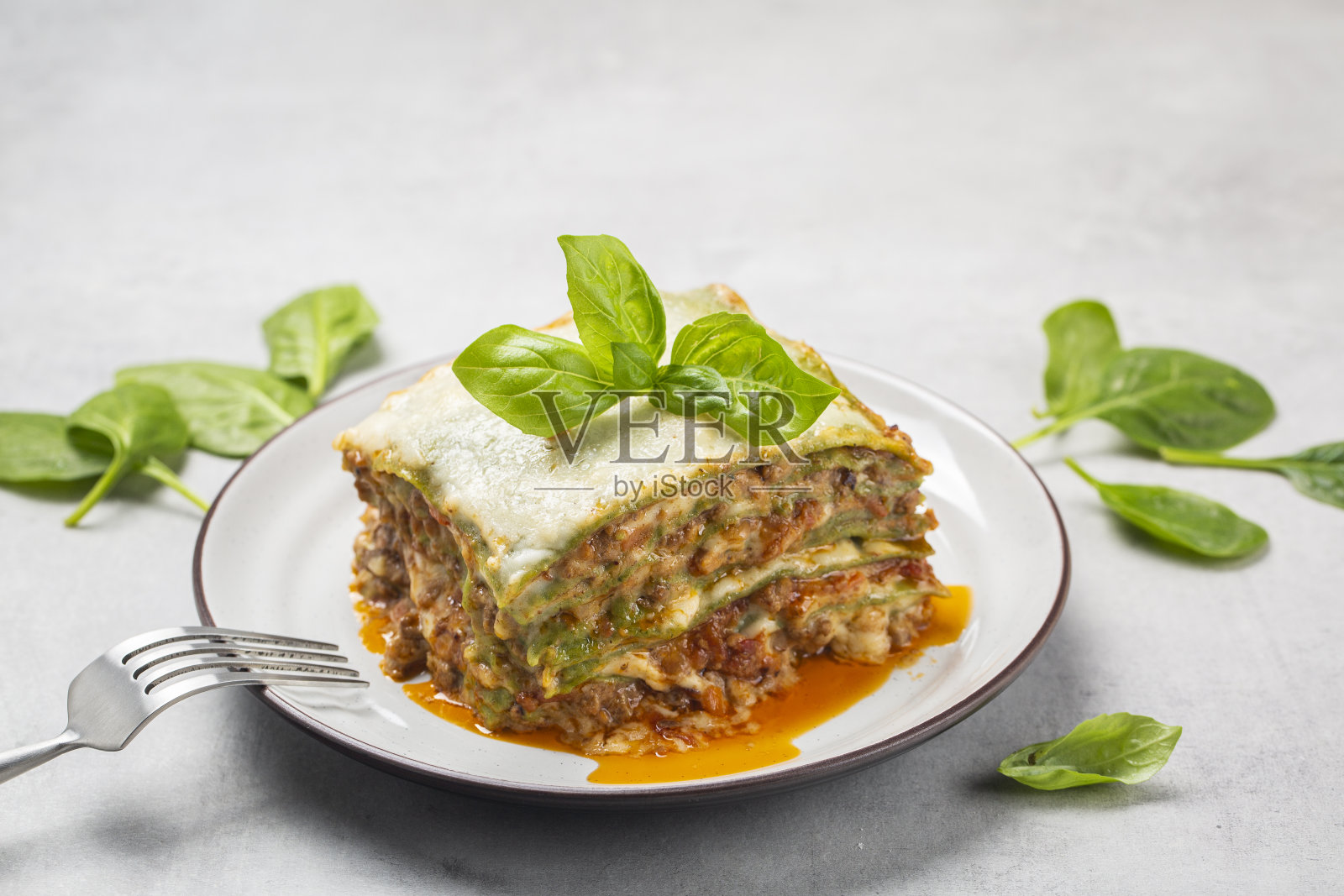 自制烤绿千层面-生面团中加入菠菜,肉酱,白汁和帕尔马干酪的烤千层面。意大利菜。特写镜头。水平的形象。照片摄影图片