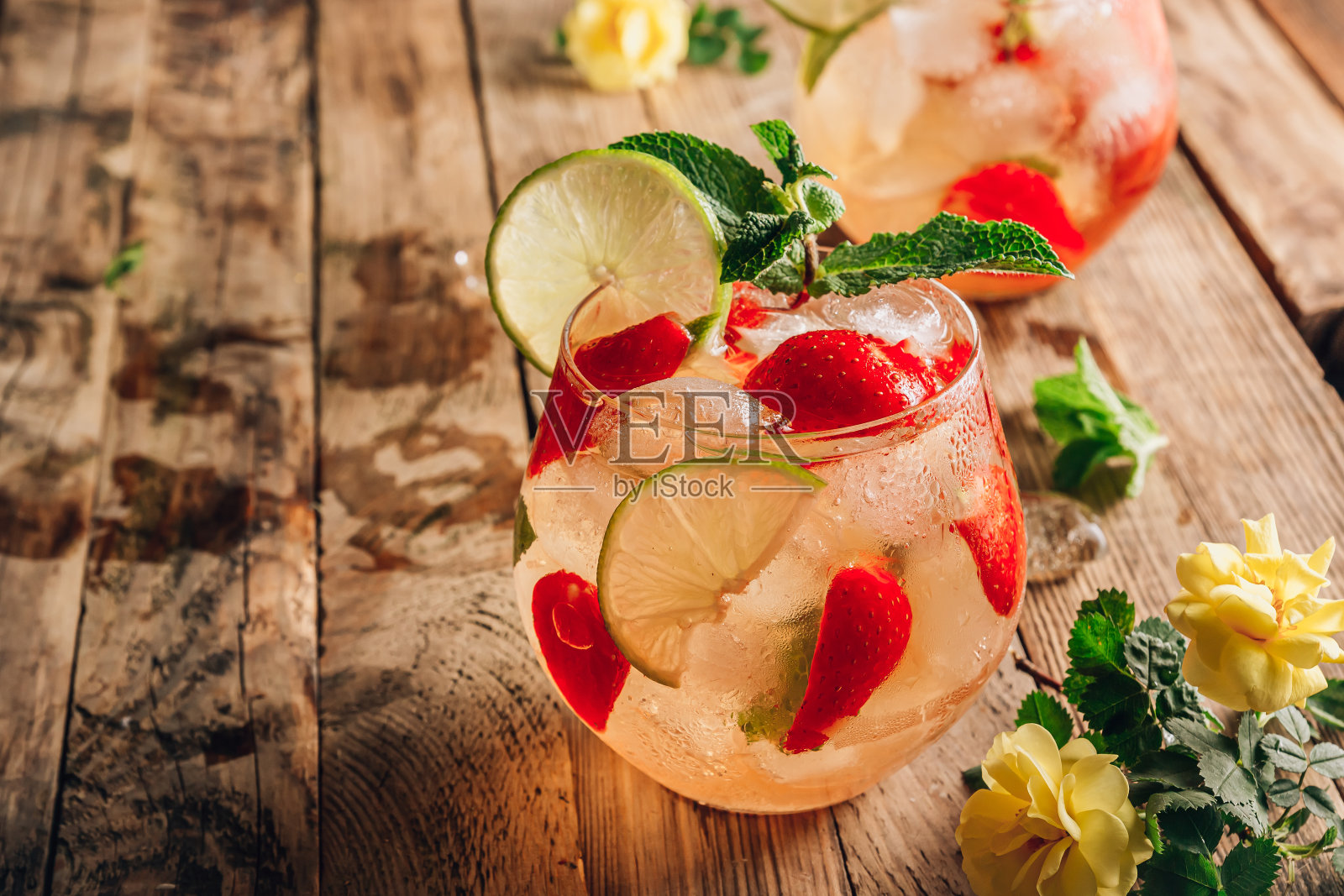 新鲜的柠檬水,绿茶,酸橙,薄荷和草莓在木制背景。寒冷的夏季饮料。两杯莓冰茶。有选择性的重点。照片摄影图片