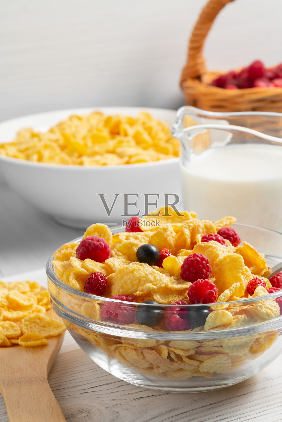 玻璃碗,麦片片,浆果和牛奶在桌子上,特写。垂直的图像照片摄影图片