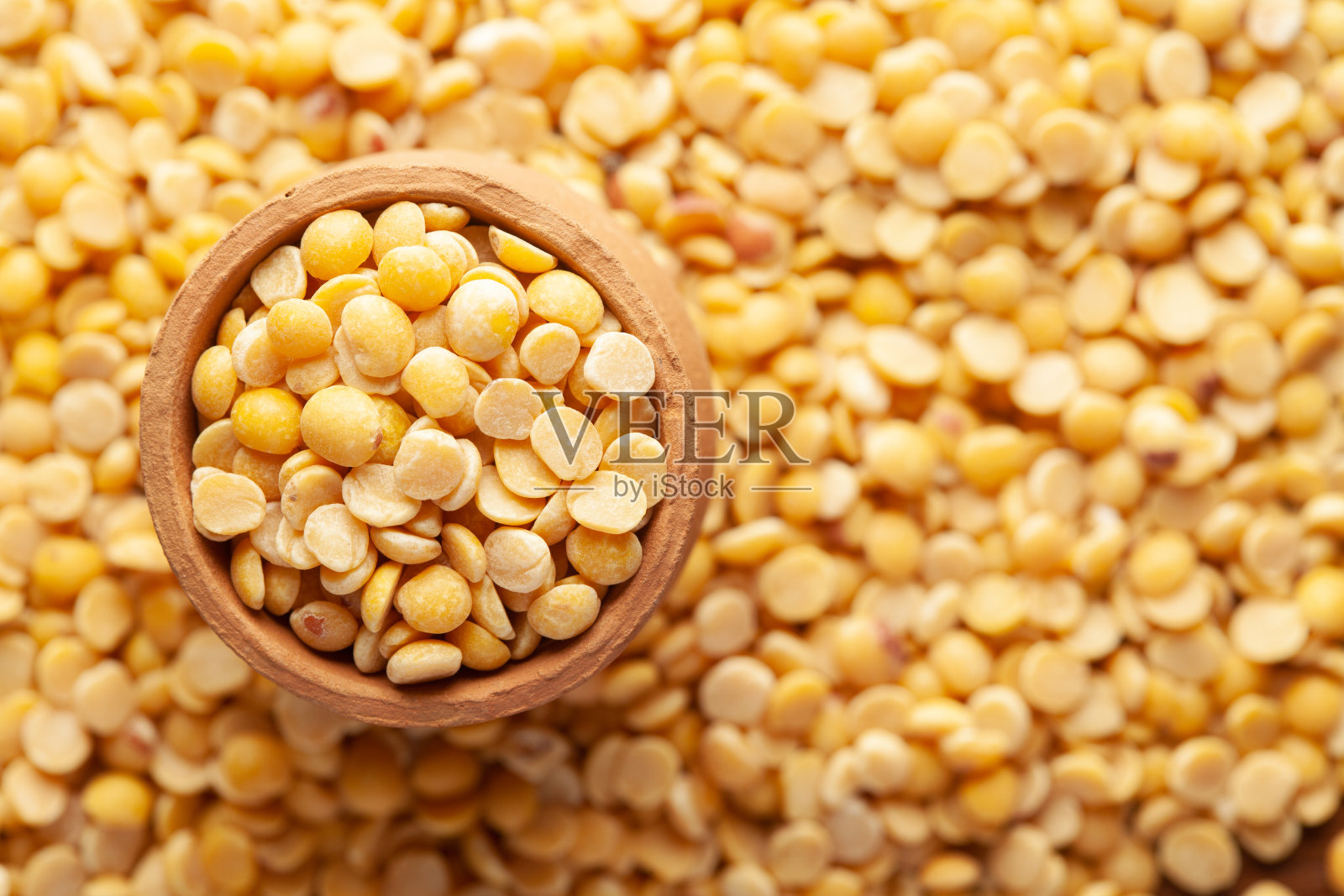 有机木豆(Cajanus cajan)的宏观特写,或分裂的黄色木豆在一个陶土锅(kulhar)的自我背景。照片摄影图片