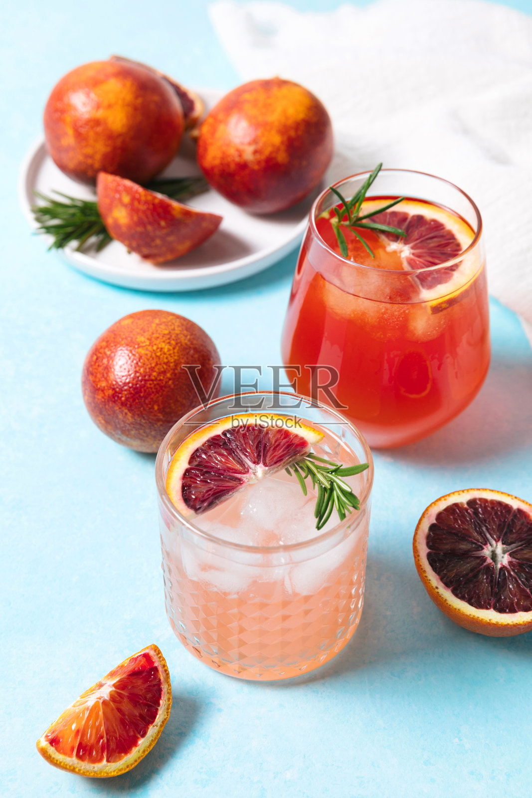 蓝色的餐桌背景,配以新鲜水果的血橙鸡尾酒。夏日鸡尾酒,柠檬水,清爽饮料,低酒精鸡尾酒,派对概念。照片摄影图片