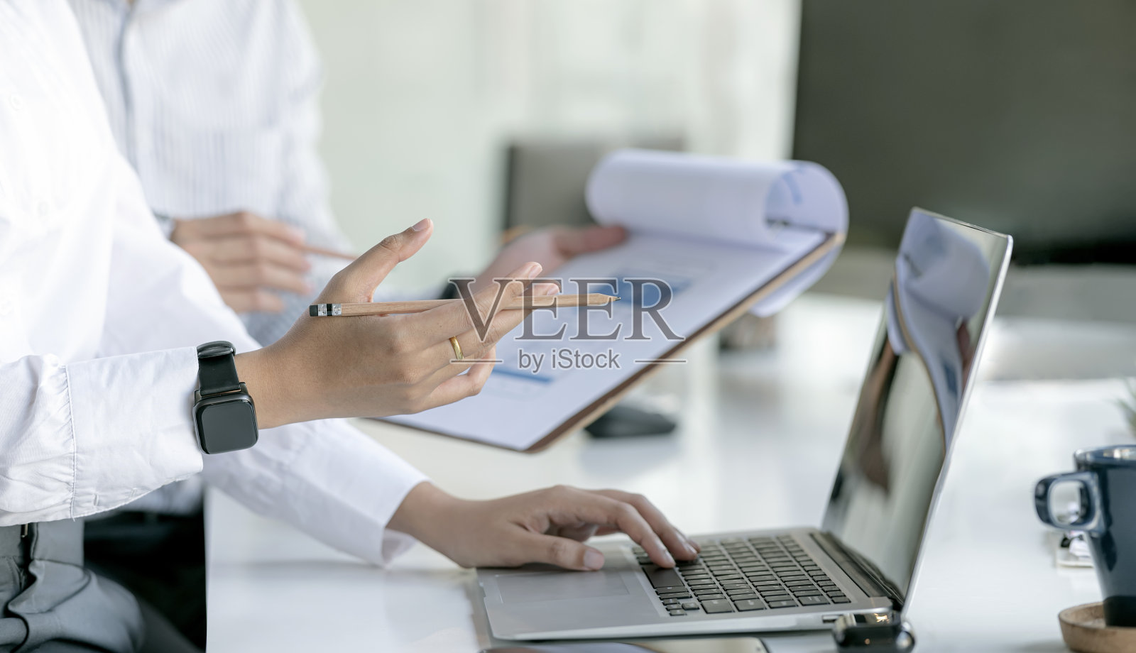 商业人士手持铅笔和使用笔记本电脑的剪影照片摄影图片