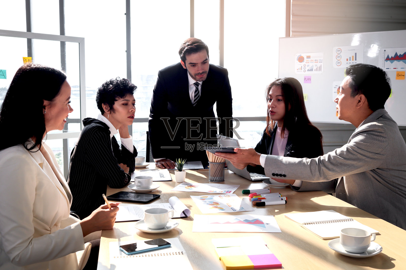 成就成功的年轻聪明的商人分享他的经验成功和演讲在会议桌,五个商务人士讨论项目工作在办公室早上,人们在工作场所照片摄影图片