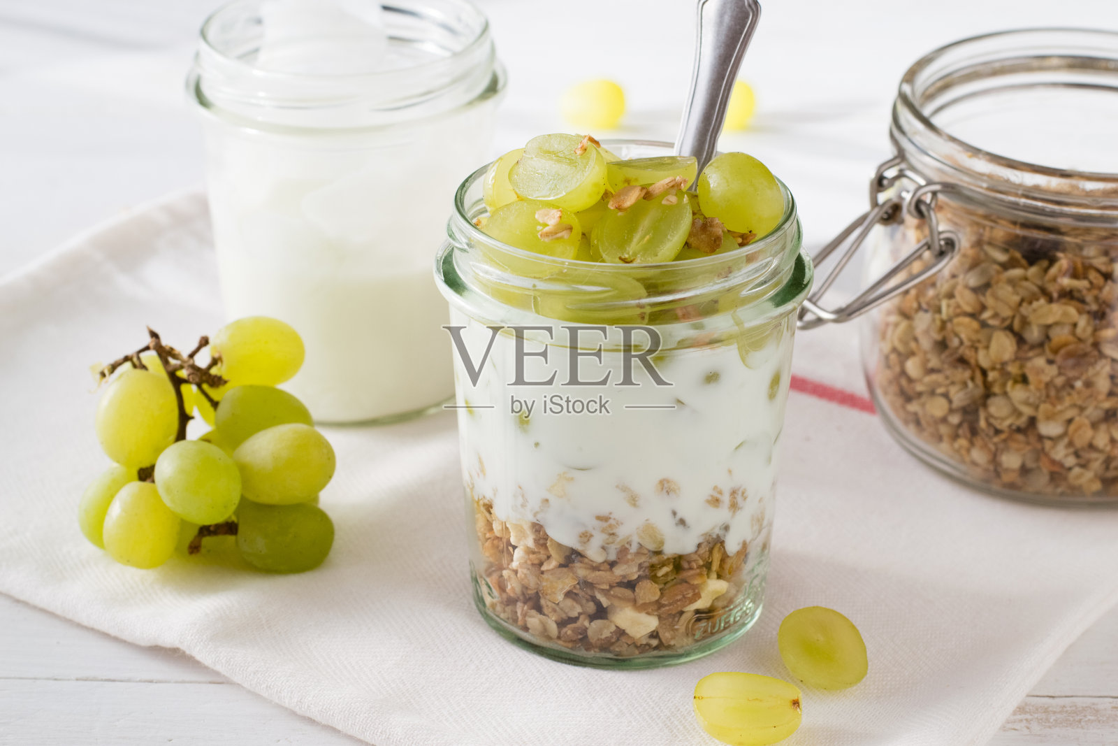 酸奶、什锦麦片和玻璃瓶里的葡萄照片摄影图片