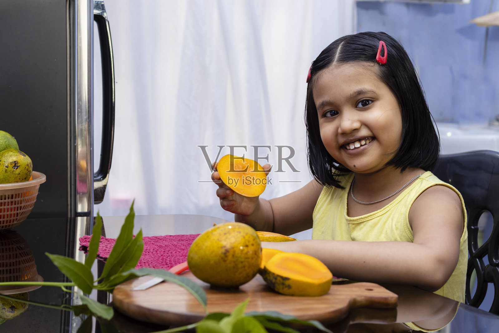 年轻的印度女孩吃芒果照片摄影图片