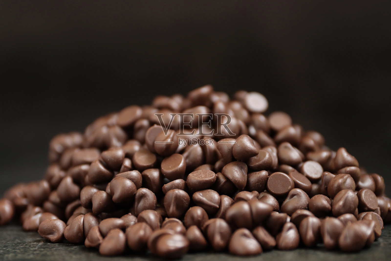 在黑色背景上的一堆黑巧克力片的特写图像,聚焦前景照片摄影图片