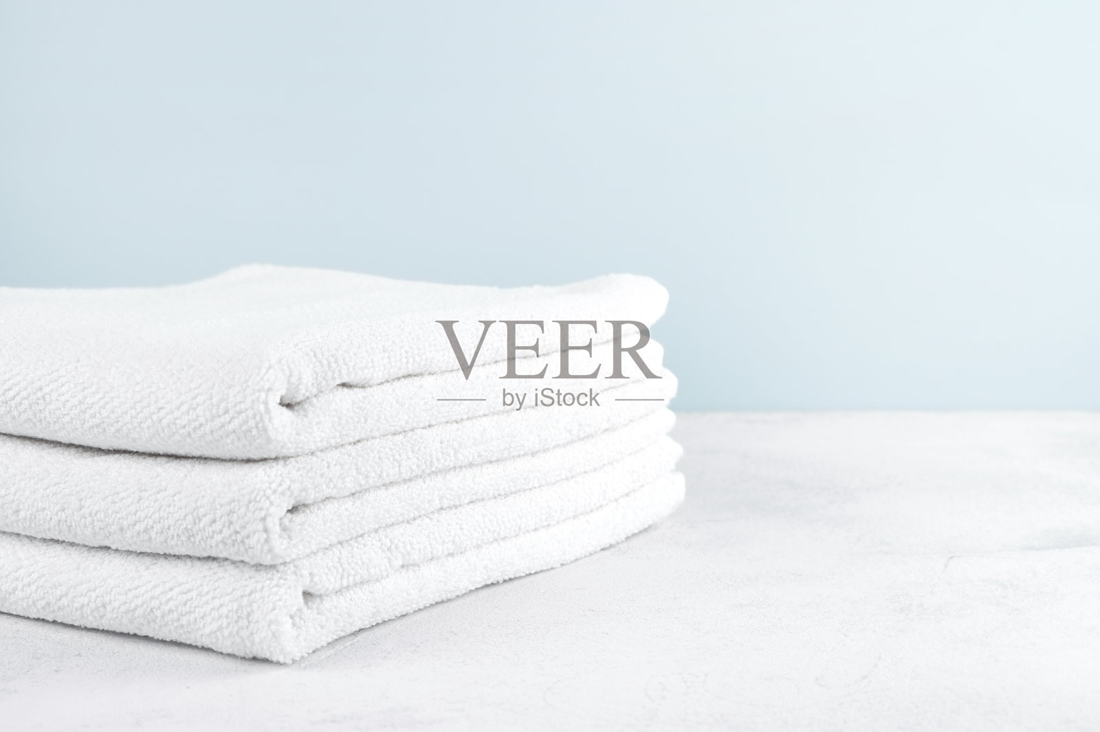 浅色背景上的白色毛巾布毛巾。照片摄影图片