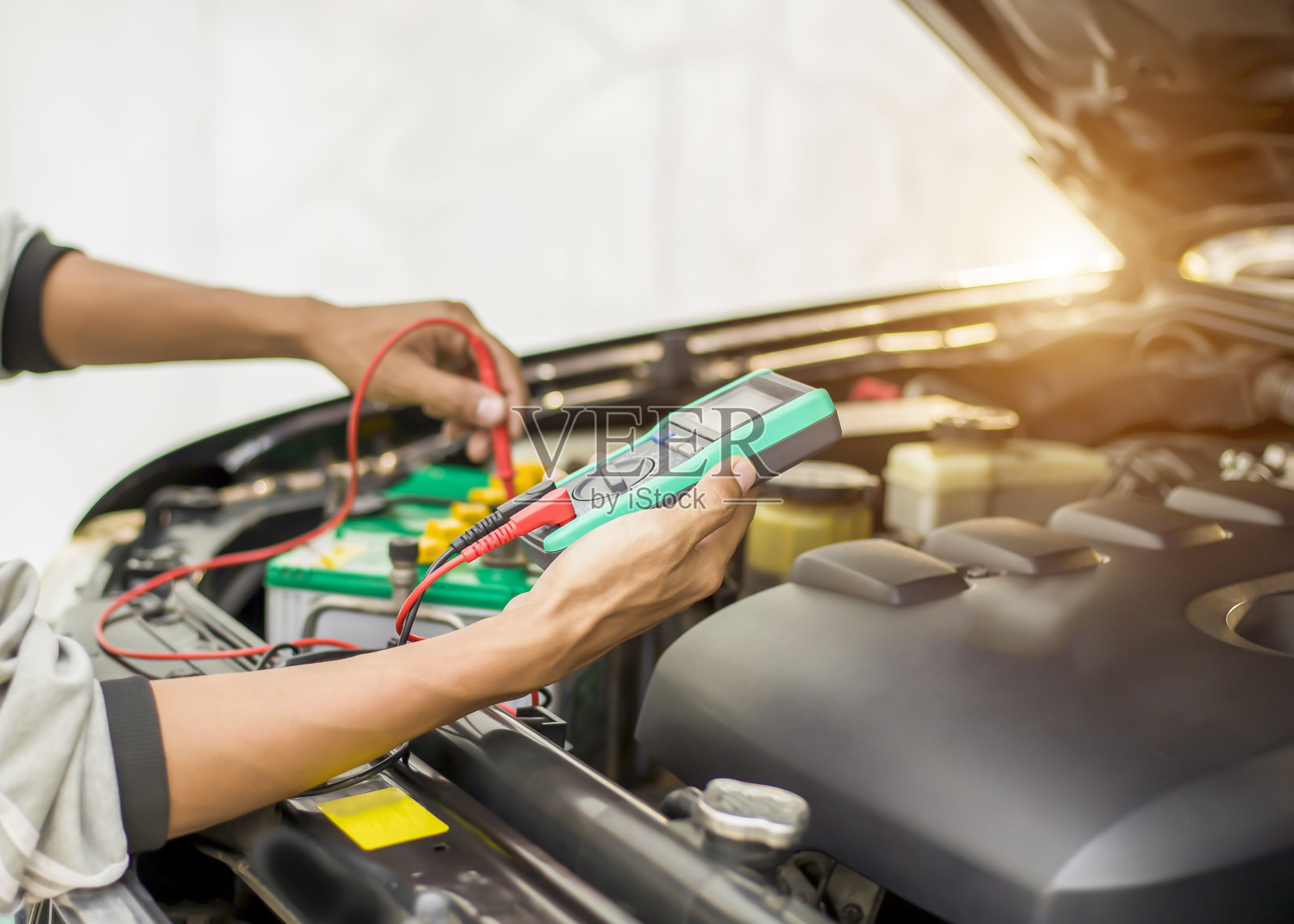 技术人员正在检查汽车电池是否可用。照片摄影图片