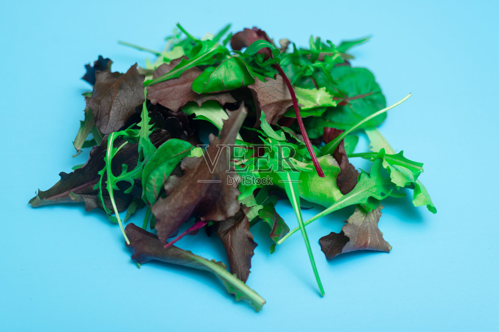 蓝色背景上的什锦新鲜蔬菜沙拉。健康、素食、生食理念。照片摄影图片