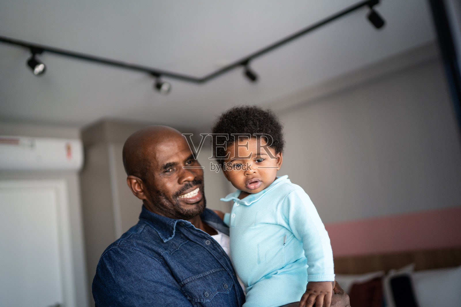 父亲在家里照顾小儿子照片摄影图片