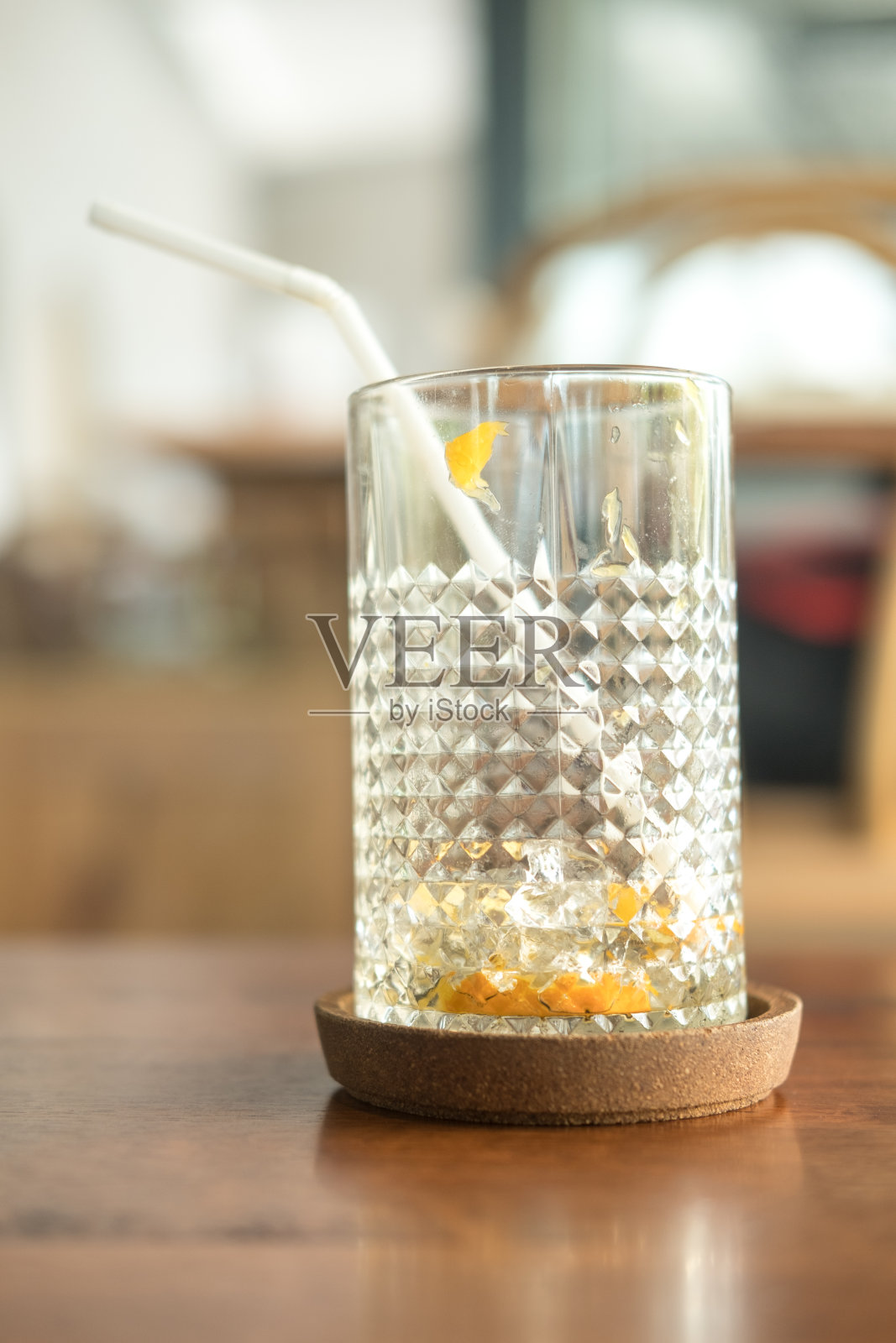 在咖啡馆里,在喝完鸡尾酒后,用白吸管将杯子倒掉,放在木碟上照片摄影图片