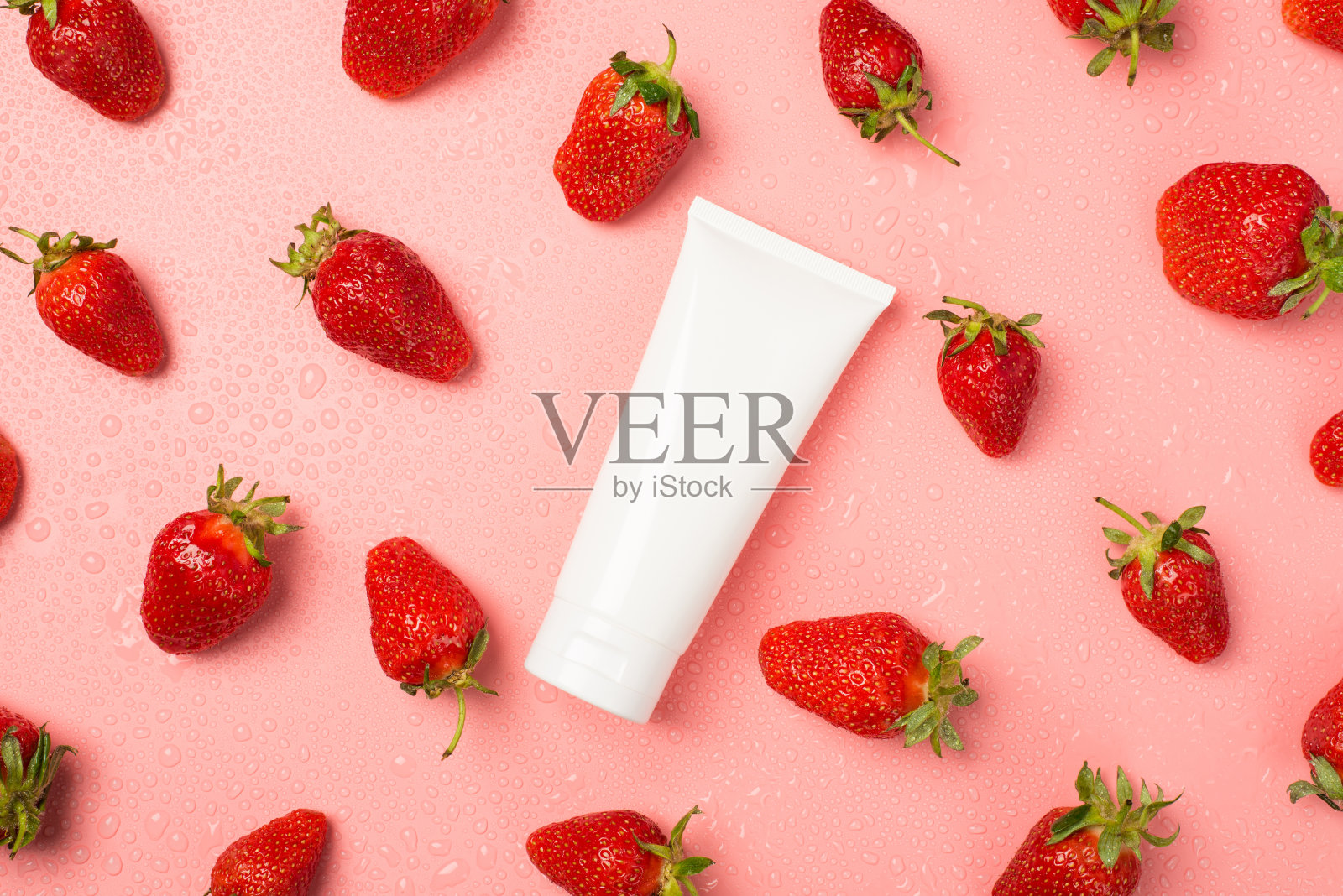 顶视图照片的白色管没有标签在中间草莓和水滴在孤立的淡粉色背景与copyspace照片摄影图片