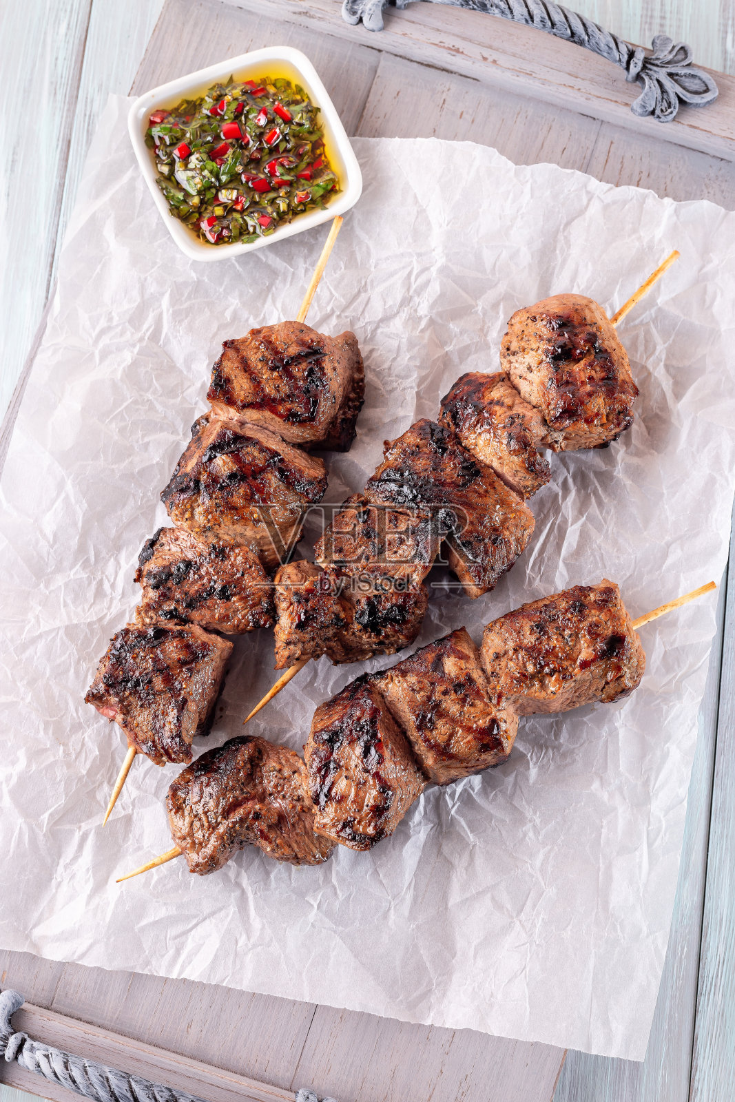 烤牛腰肉或牛肉串配辣酱,放在木托盘上,垂直俯视图照片摄影图片