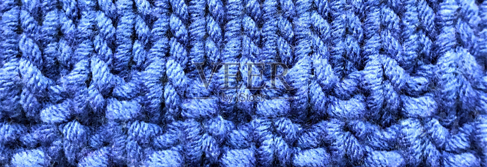 旗帜与明亮的蓝色针织织物与简单和花式图案。爱好工艺背景,拷贝空间照片摄影图片